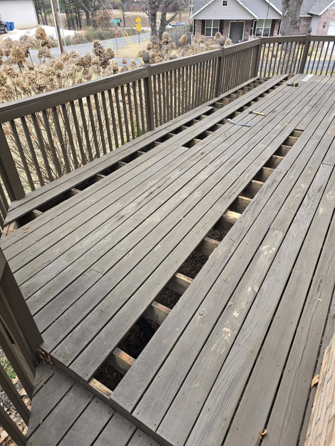 A wooden deck with several boards removed, showing deck repair in progress by Creekside Handyman NWA in Centerton, AR.