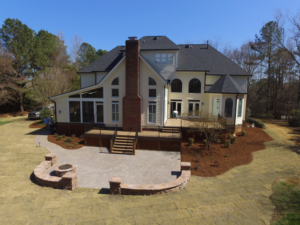 Workers constructing a new deck, screened porch, and paver patio for a home by Raleigh Deck & Screen Porch Builder in Raleigh, NC