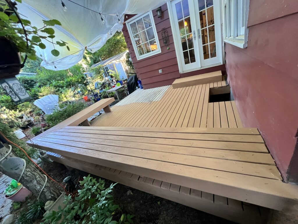 A wooden deck undergoing staining, with sections completed, by JP. Remodel Service LLC in Everett, WA.