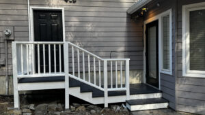 Newly constructed deck and stairs with white railings on a house exterior by Top Shelf Handyman Pros in Post Falls, ID