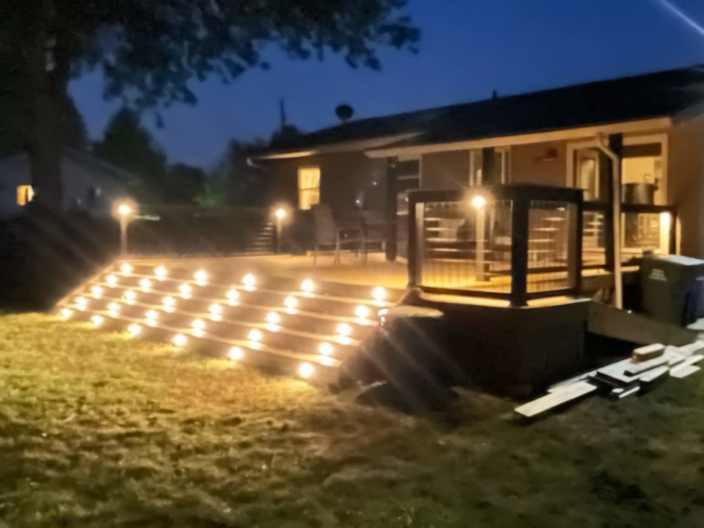 A wide night view of a newly built deck with beautifully illuminated stairs by Zig's Home Improvements in Reading, PA.