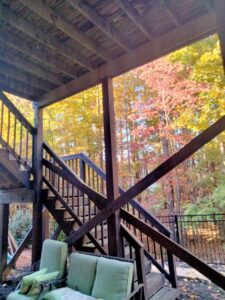 View from underneath a wooden deck, showing its structure, maintained by Mels Haul & Junk Removal in Raleigh, NC.