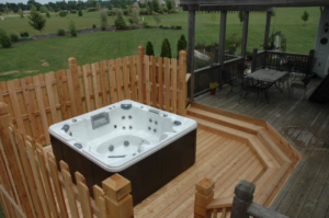 A custom wooden deck featuring a built-in hot tub and privacy fence by Holm Remodeling Company in Kansas City, KS.