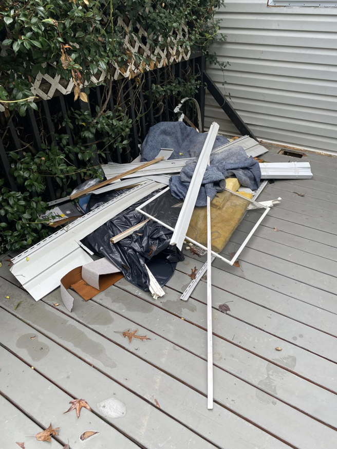 An outdoor deck covered with a pile of construction debris and discarded materials, ready for removal by Restoration Hauling Co. in Rock Hill, SC.