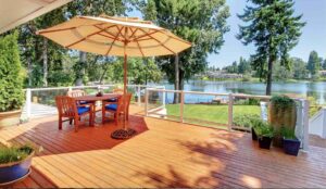 A modern deck with clear glass railings and a lake view by St. Charles Deck in St. Charles, MO