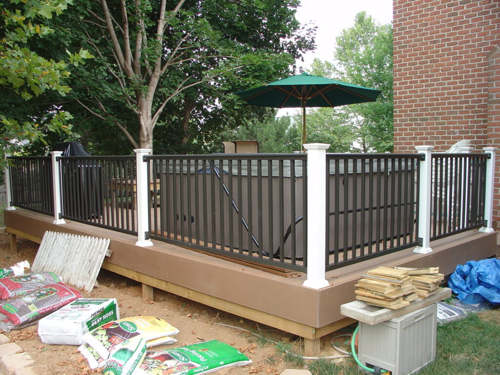 A newly built deck with a hot tub and black railings by Quality Fence & Deck Co. in Frederick, MD.