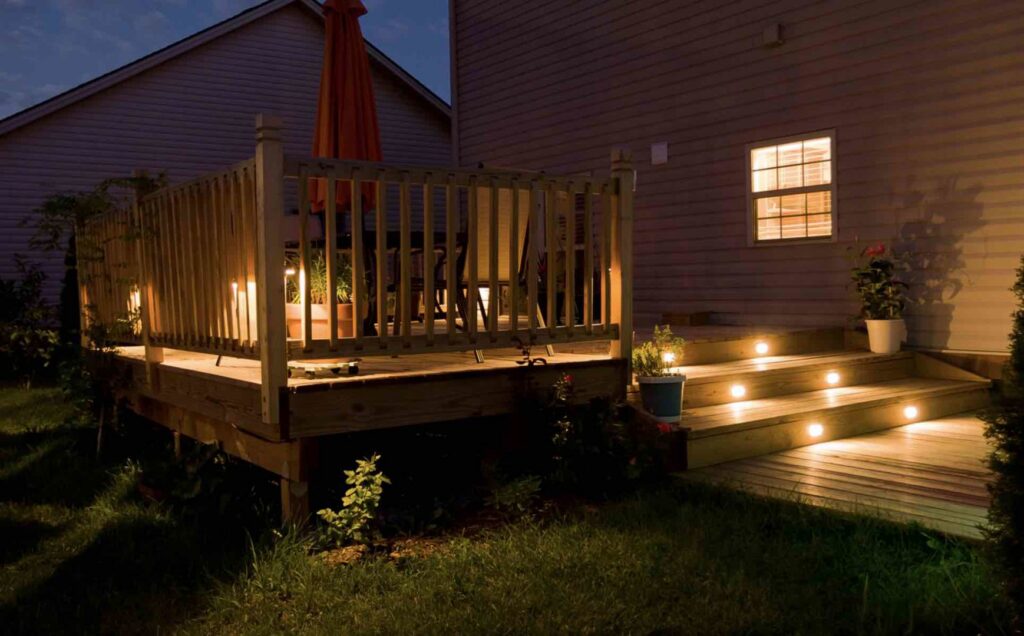 A wooden deck featuring integrated stair and railing lighting by St. Charles Deck in St. Charles, MO