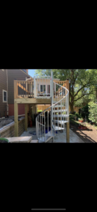 A custom-built deck featuring a modern spiral staircase installed by Chad Fry the Deck Guy LLC in Blue Springs, MO.