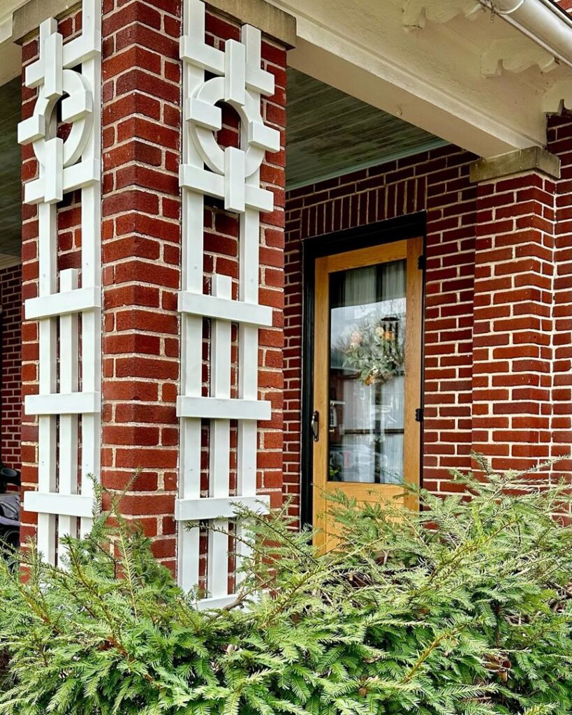 A decorative brick pillar with white wooden accents on a home's exterior by Imagine It Home Improvements Co. in Bethlehem, PA.