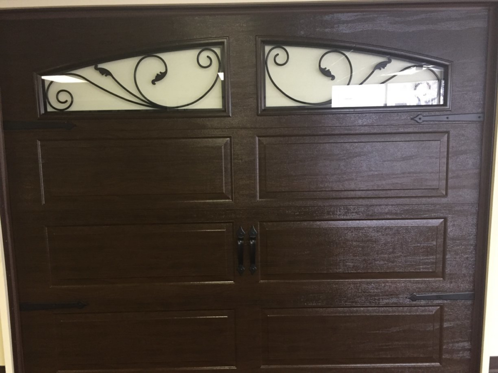 A decorative brown garage door with elegant windows and hardware, installed by Harold Carpenter Overhead Door inc in Oshkosh, WI.