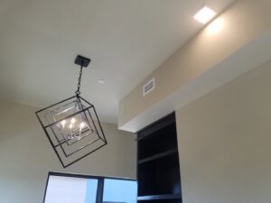A modern decorative chandelier and recessed lighting installed on a ceiling by Delaney's Electric Inc. in Ault, CO.