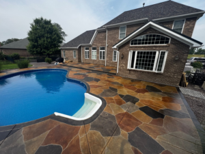 A beautifully finished decorative concrete patio coating around a swimming pool by 812 Concrete Coatings in Evansville, IN.