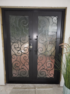 A decorative double entry door with ornate glass installed by Aluminum Fence Contractor, Inc. in Hialeah, FL.