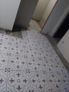 Installation of decorative patterned floor tiles in a home by TaylorMade handyman services in Roswell, NM
