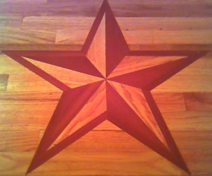 A decorative star inlay crafted into a hardwood floor by Burleson De Lago Real Hardwood Floors in Austin, TX.