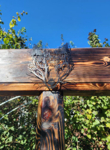 Decorative metal art piece installed on a wooden beam by SAM'S Handywork LLC in Independence, IA.
