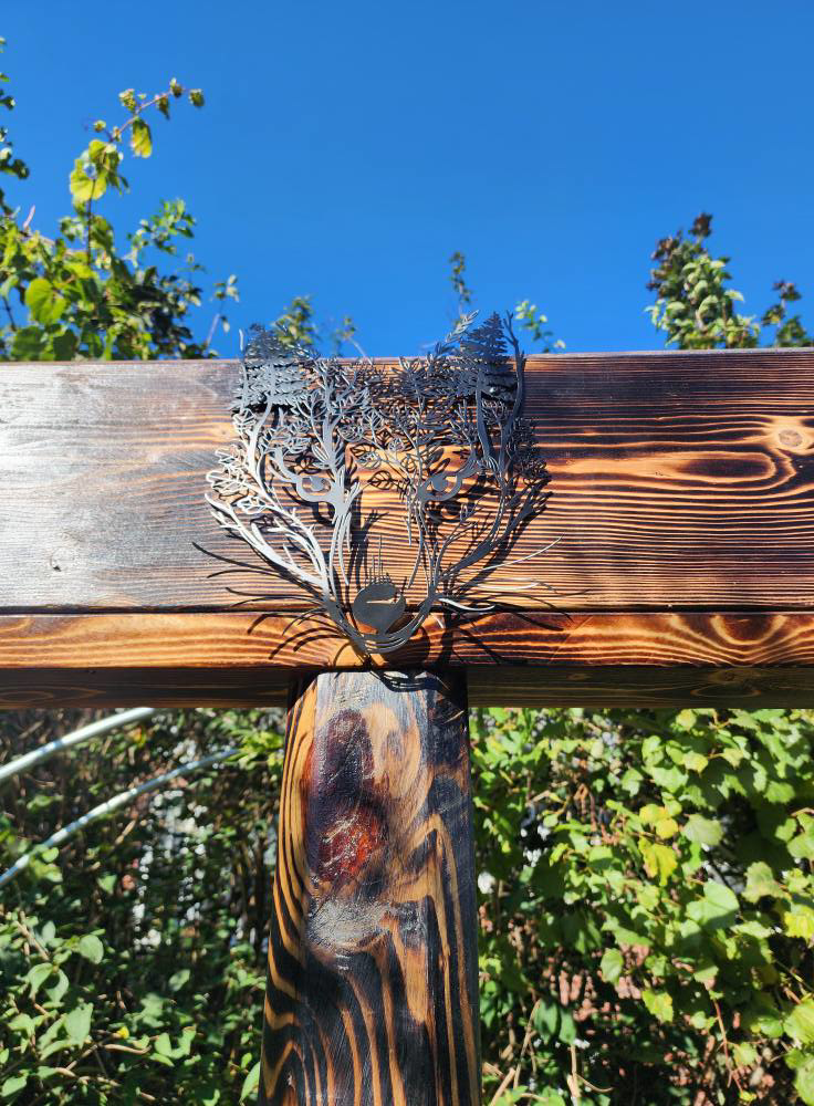 Decorative metal art piece installed on a wooden beam by SAM'S Handywork LLC in Independence, IA.