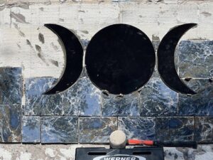 Decorative tile work being installed on a pool wall, a custom renovation service by Aqua Squad Pools & Landscaping in Gilbert, AZ.