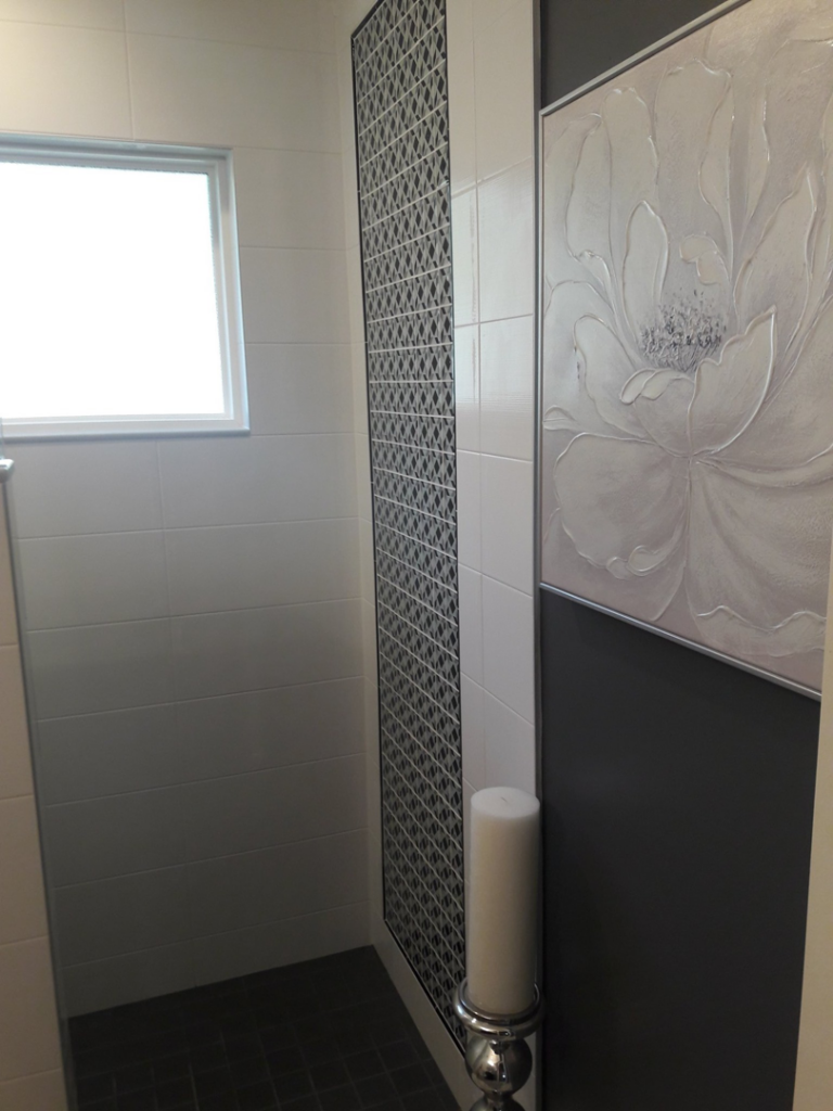 Decorative tile work on a modern bathroom shower wall completed by Guaranteed Installations in Tampa, FL.