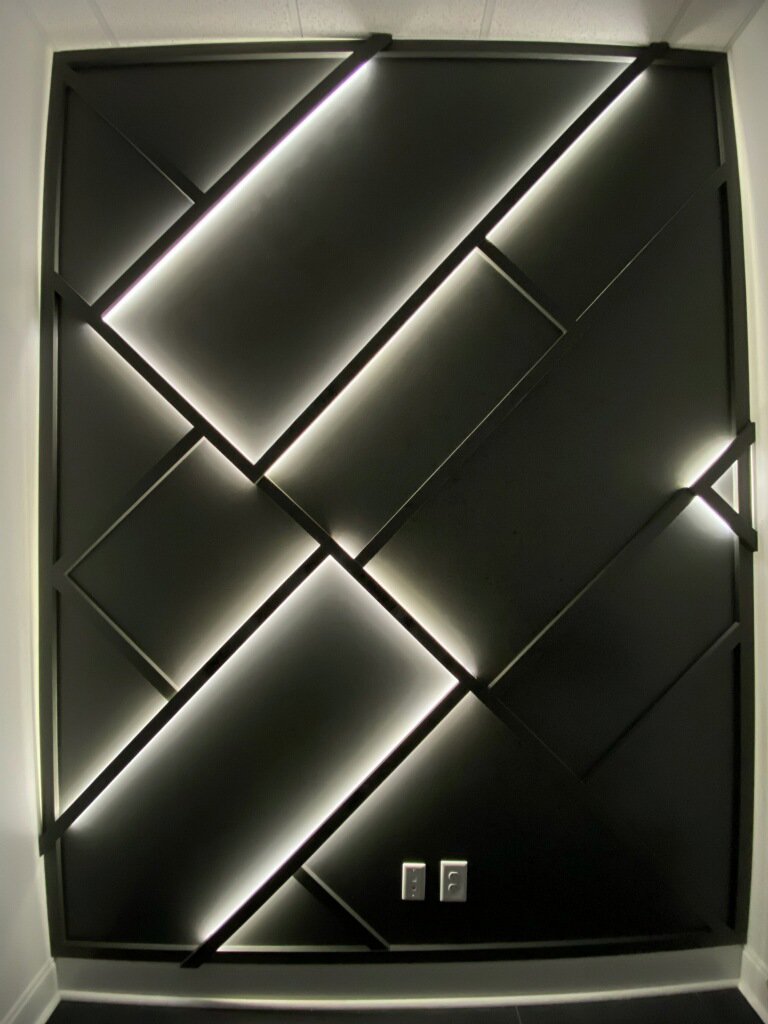 A decorative wall panel with geometric patterns and integrated LED lighting, a custom installation by Huff Consolidated Enterprises LLC in Clarksville, TN.