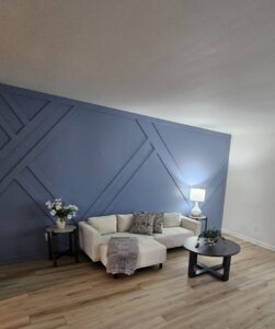 A living room with decorative blue wall paneling and new flooring installed by Imperial Access Contracting in Evansville, IN.