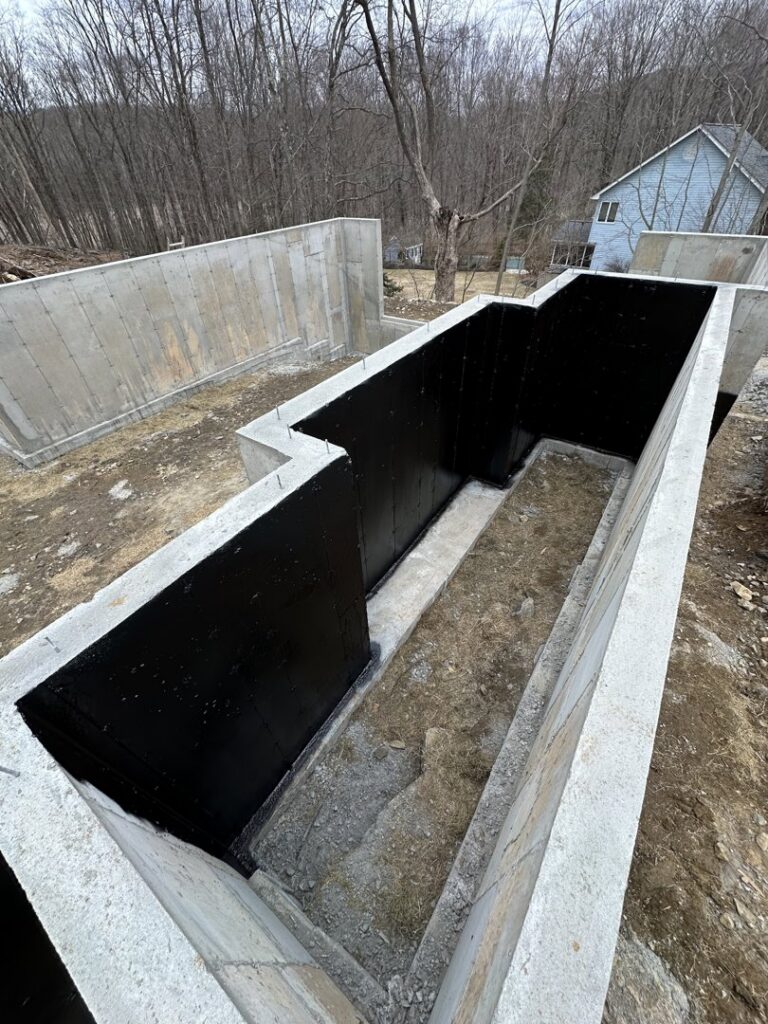 A deep foundation trench with waterproofing membrane applied by ProSeal Waterproofing in Naugatuck, CT.