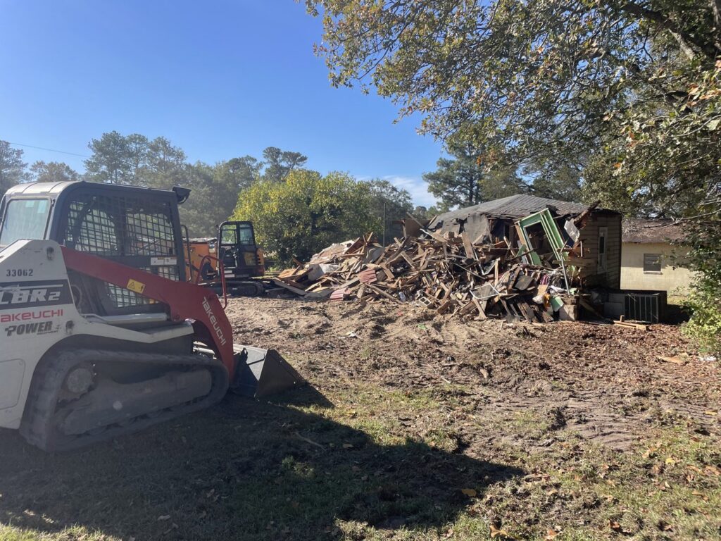 Heavy equipment clearing a large pile of demolition debris for Jr's Mini Roll Off LLC in Byron, GA.