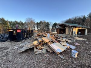 Demolition debris and a large dumpster at a job site by Insta Junk Removal & Demolition LLC in Salisbury, MD