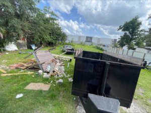 A dumpster trailer next to a pile of demolition debris for junk removal by Trash N Go Dumpster's in Orlando, FL.