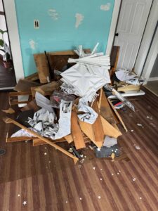 A pile of demolition debris including wood, tiles, and plaster inside a room, ready for cleanup by Junk Removal Brothers in Worcester, MA.