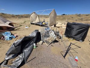A desert landscape cluttered with various debris and junk, indicating a large-scale cleanup by Rubble Removers LLC in Riverton, WY.