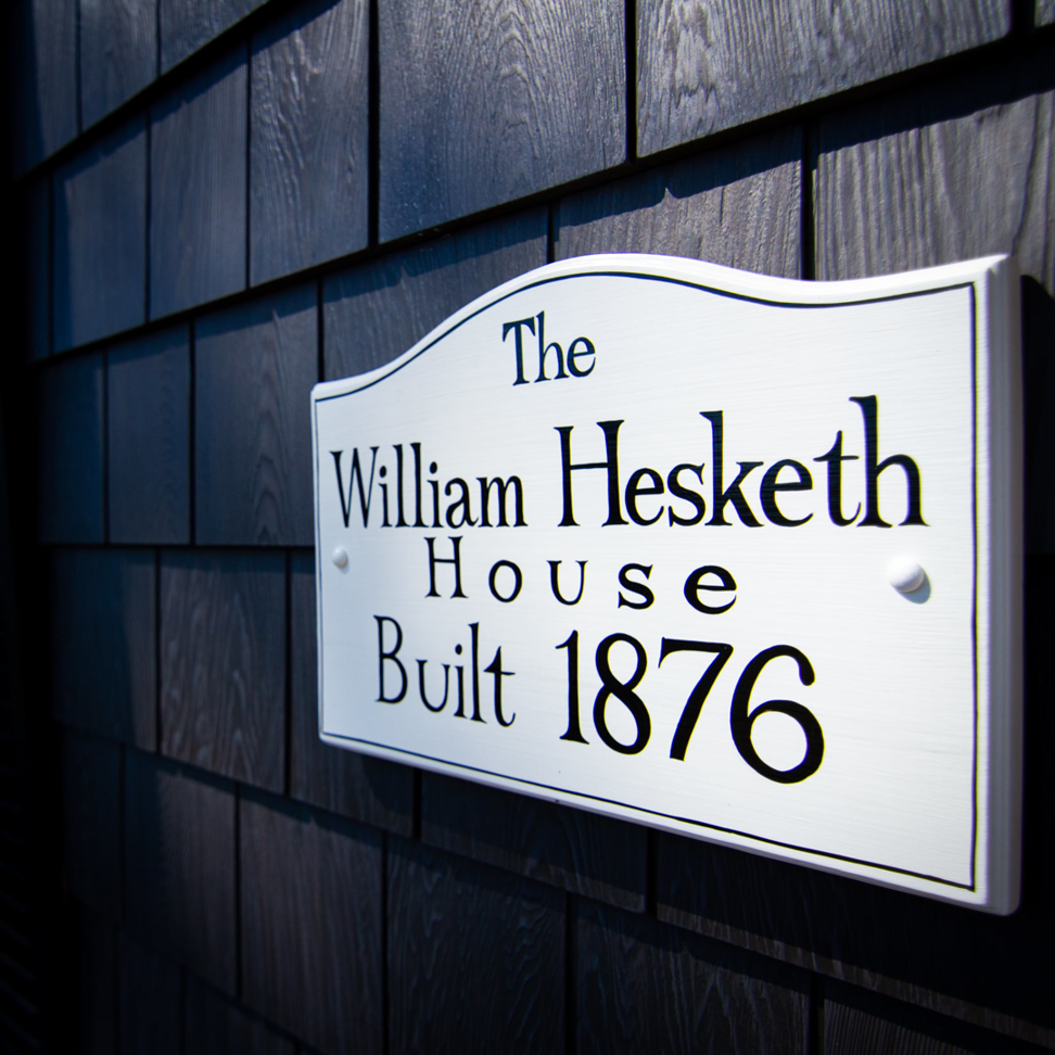 A detached garage featuring dark siding, white trim, and two garage doors, completed by Boston Exterior Remodeling in Boston, MA.