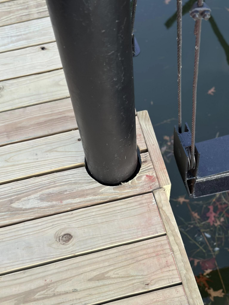 A detailed view of a dock post integrated into new wooden planks by TopNotch Remodeling & Restoration Service LLC in Warren, MI