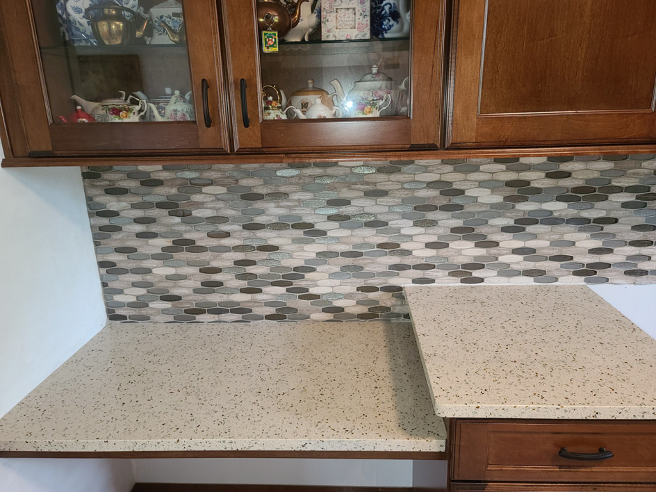 A close-up view of a beautifully installed kitchen backsplash and speckled countertop by J & J Home Improvements, LLC in Franklin, TN.