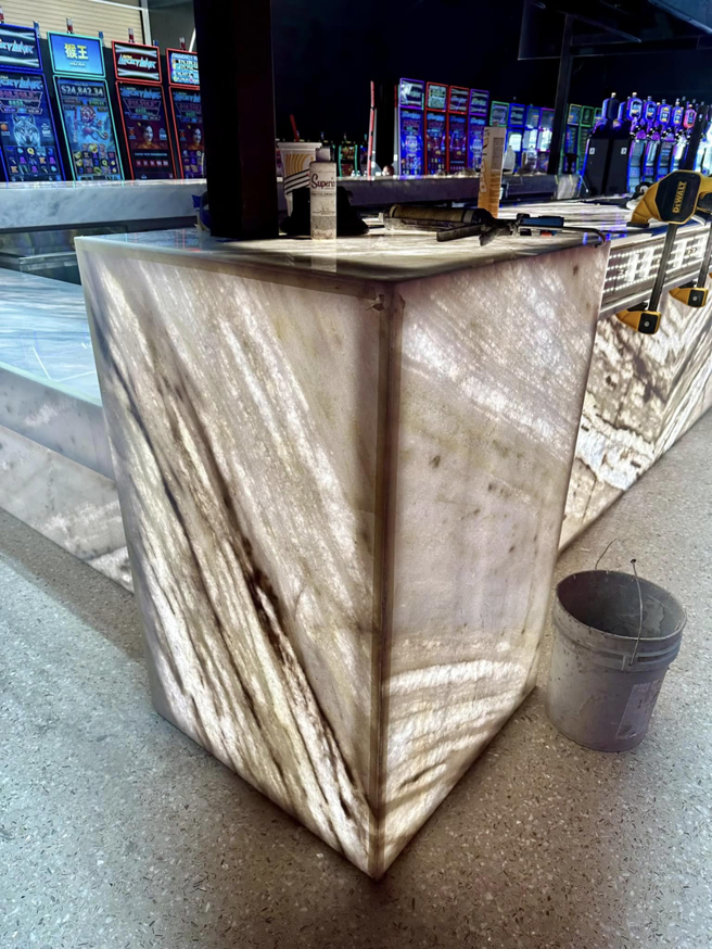A detailed close-up view of the illuminated marble bar counter, a high-quality general contractor installation by COMAF Marble & Granite in El Paso, TX.