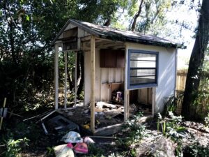 A dilapidated shed with debris scattered inside and around it, ready for removal by Pro Dumpsters & Junk Removal in Orlando, FL.