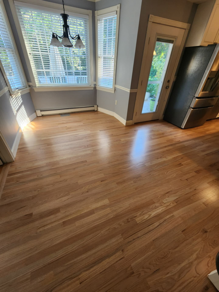 A bright dining area featuring a newly installed light hardwood floor by floorzone.inc in Los Angeles, CA.