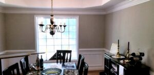 A dining room with elegant wainscoting and freshly painted walls completed by Global Painting RVA in Richmond, VA.