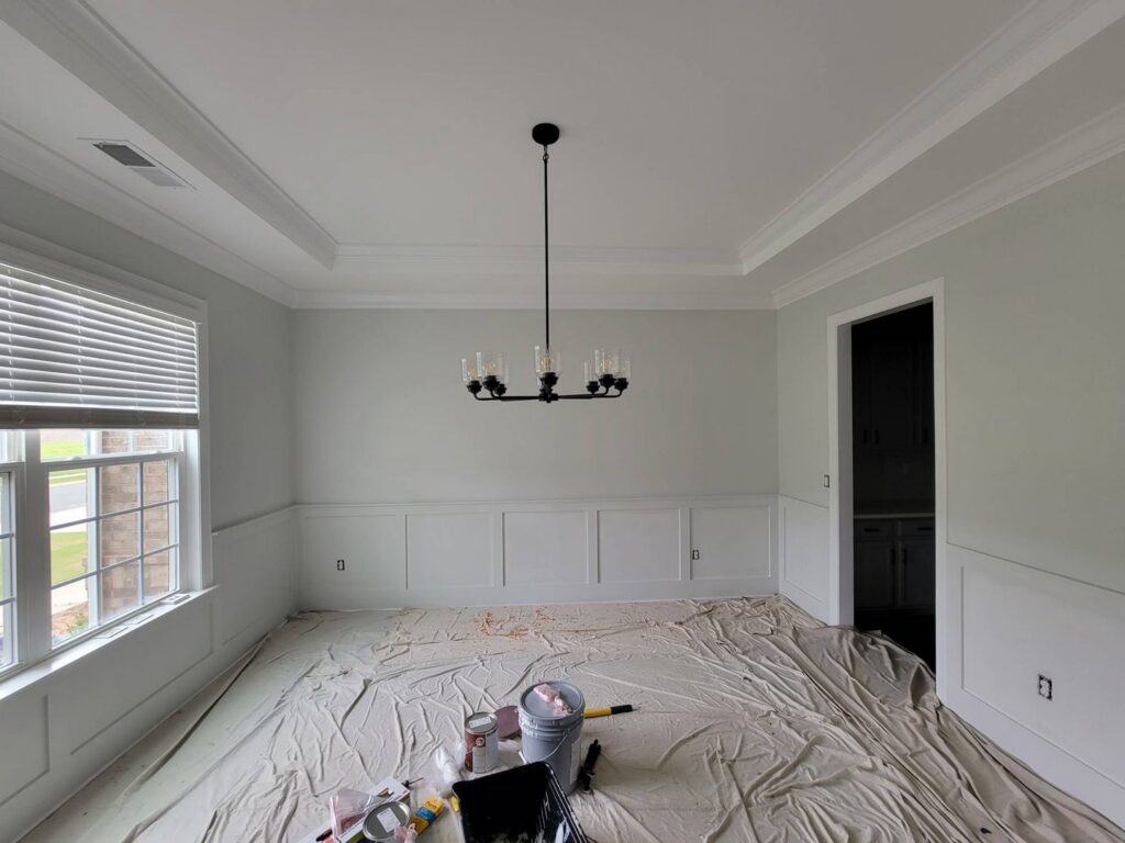 A dining room with freshly painted walls, wainscoting, and crown molding by Prime Painting in Charlotte, NC.