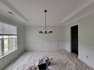 A dining room with freshly painted walls, wainscoting, and crown molding by Prime Painting in Charlotte, NC.