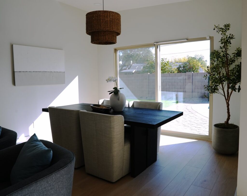 A dining room featuring a newly installed woven pendant light fixture, showcasing work by American Wolf Construction in Mesa, AZ