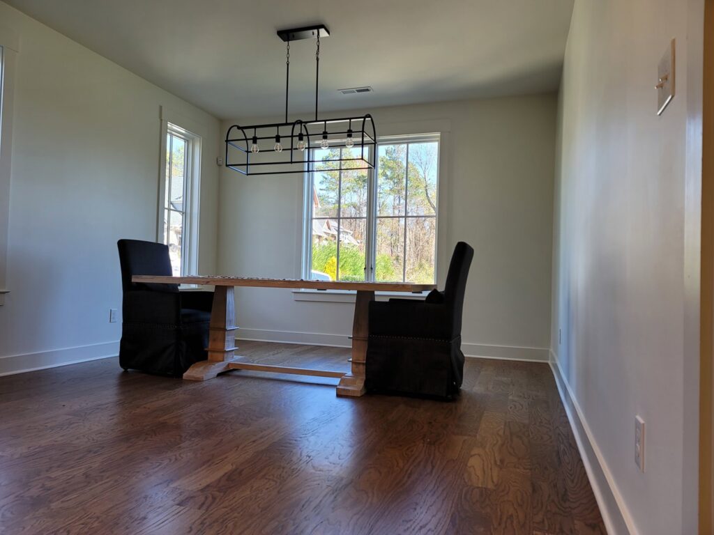 A dining room with fresh paint and a modern light fixture installed by Painting Pros of Knoxville in Knoxville, TN.
