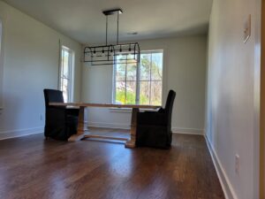 A dining room with fresh paint and a modern light fixture installed by Painting Pros of Knoxville in Knoxville, TN.