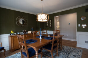 A renovated dining room featuring dark green wallpaper and wainscoting by Pluff Contractors LLC in Lancaster, PA.