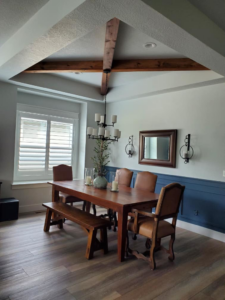Dining room renovation featuring decorative ceiling beams, chandelier, and wainscoting by IGM Handyman Services in Meridian, ID.