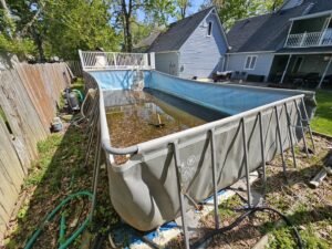 A large, dirty above-ground pool filled with stagnant water and debris, ready for removal by T&G Dumping in Lorain, OH.
