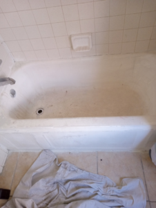 A dirty and worn bathtub before refinishing, showing a handyman project by Charles and Drew Project Page in Detroit, MI.
