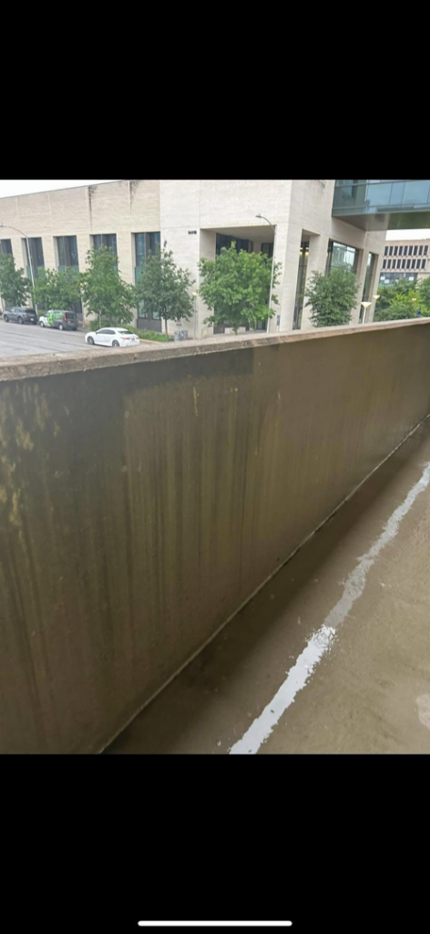 A dirty commercial wall showing grime buildup before cleaning by RWD Construction in San Antonio, TX.