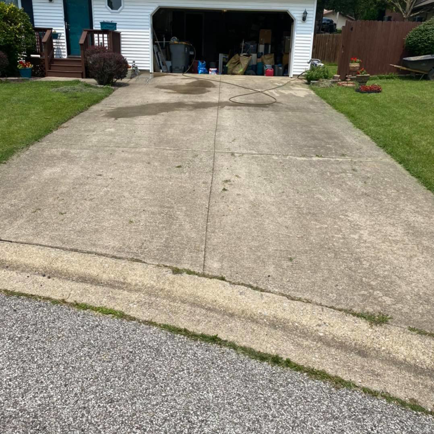 A dirty concrete driveway showing grime and stains before pressure washing by Carter's Handyman Service and Remodeling in Bloomington, IN.