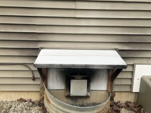 A dirty exterior vent with a small awning, showing an area for handyman cleaning or maintenance by Phoenix's Cleaning Service, LLC in Rutland, VT.